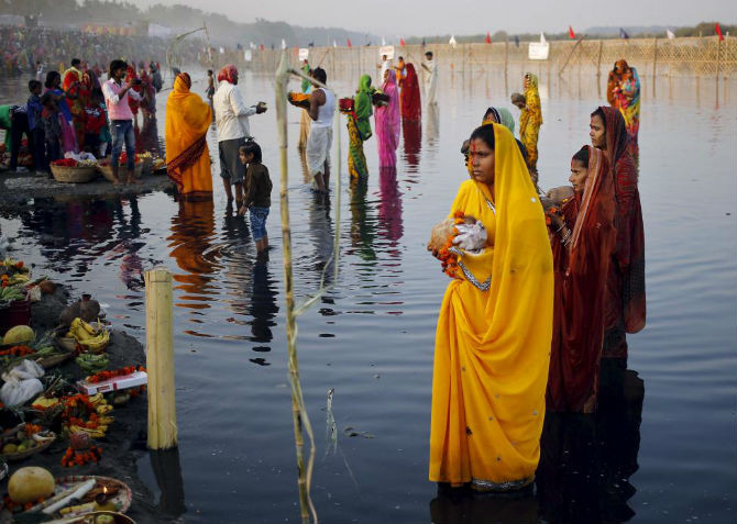 Những người theo đạo Hindu dâng lễ cúng thần Mặt Trời trên sông Yamuna ở New Delhi, Ấn Độ, ngày 17/11/2015 trong dịp lễ Chahat Puja – một lễ hội tôn giáo kéo dài bốn ngày.