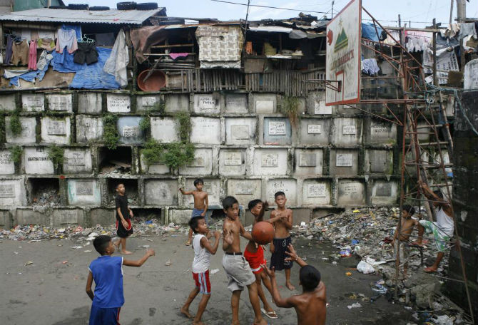 Các em nhỏ chơi bóng rổ trong nghĩa địa ở Manila ngày 21/10/2008.
