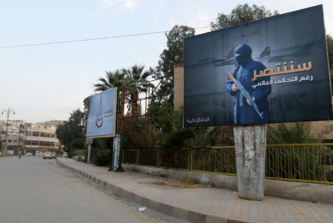 Hình ảnh Nhà nước Hồi giáo IS tự xưng trong biển quảng cáo trên một con đường ở Raqqa ngày 29/10/2014. “Chúng ta sẽ giành chiến thắng bất chấp liên minh toàn cầu” là nội dung dòng chữ trên tấm biển bên phải.