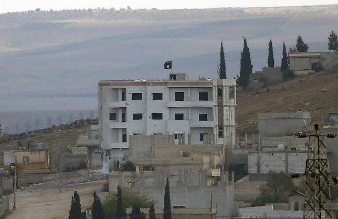 Một lá cờ của tổ chức Hồi giáo IS tự xưng trên nóc của một tòa nhà ở Kobani ngày 1/11/2014.