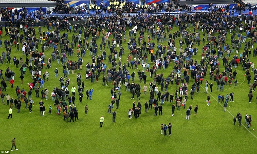 Người hâm mộ bóng đá chạy ùa vào sân vận động Stade de France nơi diễn ra trận đấu bóng giữa Pháp-Đức sau khi vụ nổ xảy ra bên ngoài sân vận động này.