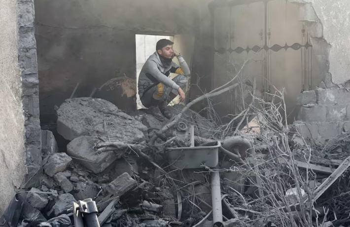 Người đàn ông ngồi giữa đống đổ nát sau khi ngôi nhà bị phá hủy ở Rafah, phía nam Dải Gaza, ngày 14/12/2023.