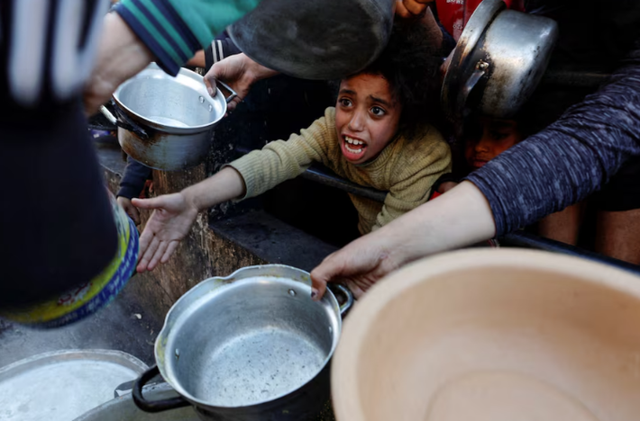 Người dân Palestine chờ nhận thực phẩm trong tháng ăn chay Ramadan của người Hồi giáo, tại Rafah, phía Nam Dải Gaza, ngày 13/3/2024.