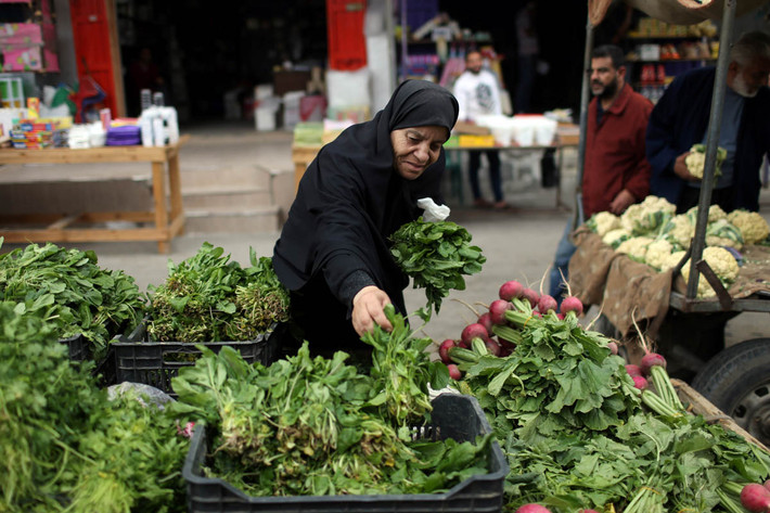 Người phụ nữ Palestine bán rau xanh trong một khu chợ ở phía nam Dải Gaza.