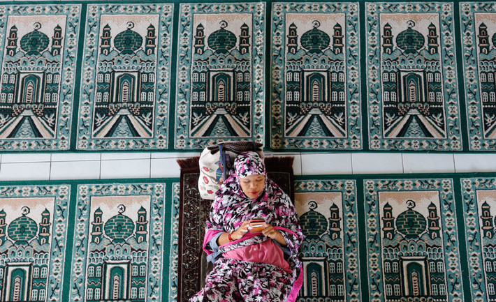 Một phụ nữ ngồi nghỉ tại nhà thờ Hồi giáo trong ngày đầu tiên của tháng Ramadan tại Bali, Indonesia.