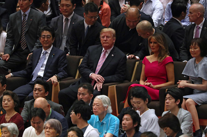 Thủ tướng Abe ngồi cạnh Tổng thống Trump và phu nhân Melania cùng mọi người chăm chú theo dõi trận đấu của các võ sĩ sumo. Ảnh: AP.