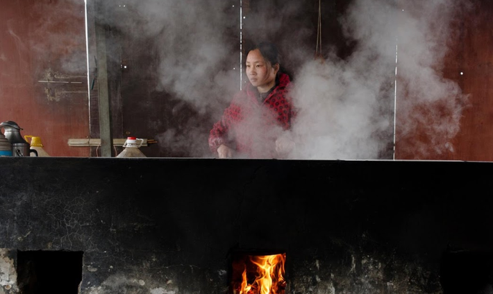 Jiejie Li, vợ của Sun Lianxi, nấu ăn trong ngôi nhà tạm bợ của họ trên bờ sông Hoàng Hà.
