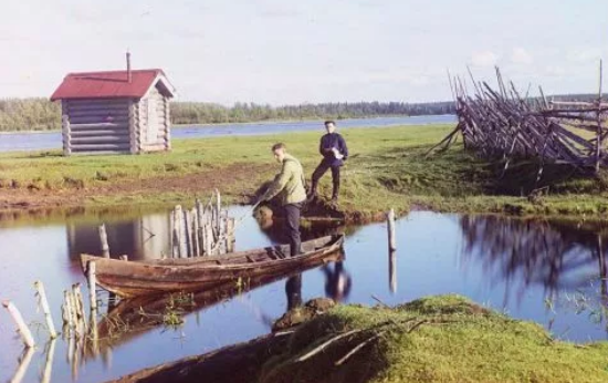 Người đàn ông Nga đứng trên thuyền giữa sông.