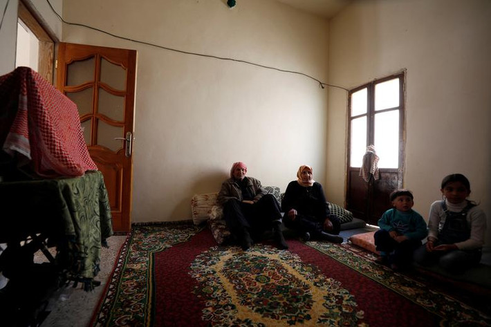 Ông Hassan Ahmed al-Aoul cùng vợ Aisha, 60 tuổi, và các cháu ngồi trong nhà ở Salaheddine. Được biết, vợ chồng ông Hassan đã phải vay mượn tiền để sửa sang lại ngôi nhà của họ do nó đã bị tàn phá nặng nề trong chiến tranh.