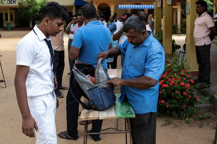 Người đàn ông kiểm tra túi của một học sinh tại ngôi trường ở Batticaloa, Sri Lanka, ngày 6/5.