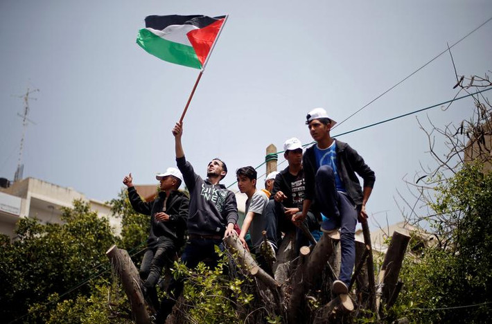 Người dân Palestine trèo lên cây trong cuộc tuần hành tại thành phố Gaza.