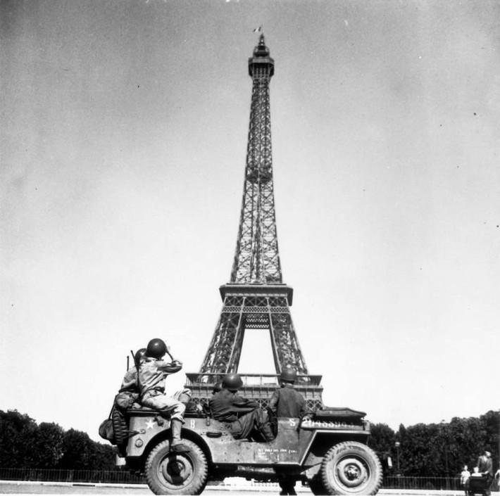 Các binh sĩ đến từ Sư đoàn Bộ binh số 4 của Mỹ ngồi trên xe jeep và nhìn về phía Tháp Eiffel.