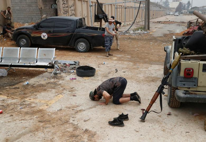 Tay súng GNA cầu nguyện trên chiến trường ở ngoại ô thủ đô Libya.