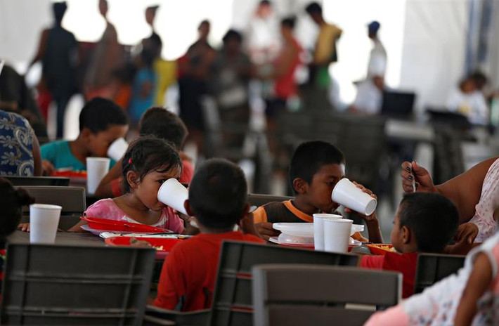 Các em nhỏ nhập cư Venezuela ngồi ăn trưa trong phòng ăn của khu trại ở Maicao ngày 6/5. Mời độc giả xem thêm video: Nền y tế Venezuela khủng hoảng vì bác sĩ rời bỏ đất nước (Nguồn: VTC14)