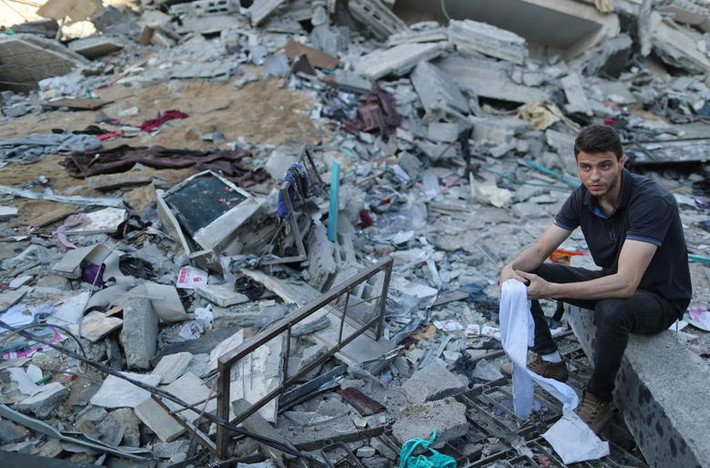Một người đàn ông Palestine ngồi giữa đống đổ nát của một ngôi nhà bị phá huỷ ở thành phố Gaza ngày 5/5.