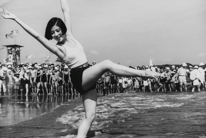 Một cô gái đang múa ở bãi biển Yuigahama ở Kamakura, năm 1934. Ảnh của Kamakura không được biết tới bên ngoài một nhóm nhỏ, cho đến một đợt trưng bày lớn vào năm 1973. Đó là lần đầu tiên các tấm ảnh từ những năm 1930 được công bố trước công chúng Nhật Bản, và đối với những người sống sót qua Thế chiến, những hình ảnh này khiến họ hồi tưởng sâu sắc. Ảnh: Kineo Kuwabara.