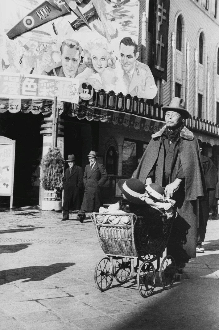 Một người đàn ông đẩy xe chở hai cô gái năm 1936. Trong ảnh của Kuwabara, dường như không có nhiều khoảng cách giữa nhân vật và người chụp. Trước đó một năm, một cuộc đảo chính bất thành đã khiến dân chúng bất an nhưng ảnh của ông thường cho thấy sự thờ ơ với thế sự, trong đó con người vẫn sống bình thường. Ảnh: Kineo Kuwabara.