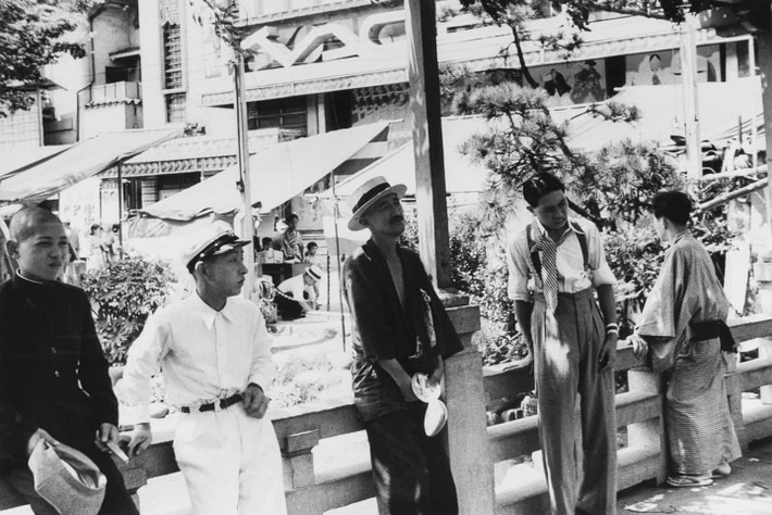 Một ngày nắng đẹp ở quận Asakusa năm 1936. Có sự tương phản giữa hiện đại và truyền thóng ở Nhật: một thanh niên mặc trang phục phương Tây, trong khi người đàn ông ở bên phải mặc quần áo truyền thống. Ảnh hưởng của phương Tây càng bị chê bai khi càng gần chiến tranh thế giới. Ảnh: Kineo Kuwabara.