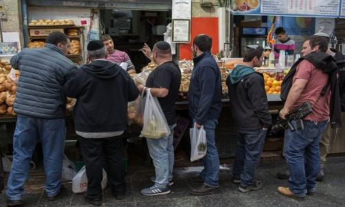 Người dân Israel mua đồ tại khu chợ nhộn nhịp ở Mahane Yehuda, Jerusalem. Ảnh: NYT.