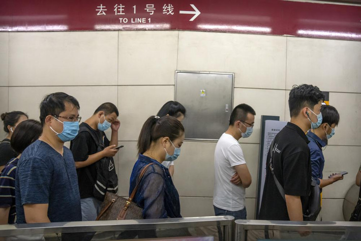 Người dân đeo khẩu trang phòng lây nhiễm COVID-19 khi đi qua một nhà ga tàu điện ngầm trong giờ cao điểm buổi sáng ở thủ đô Bắc Kinh ngày 4/8. Ảnh: AP.