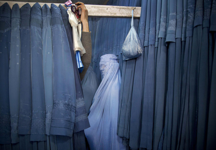 Một phụ nữ Afghanistan đợi trong phòng thay đồ để thử chiếc áo burqa mới trong một cửa hàng ở Kabul, Afghanistan, ngày 11/4/2013.