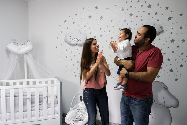 Emmanuelle Lteif Khnaisser và chồng chơi đùa với con trai, bé George, tại ngôi nhà ở Jal el-Dib, Li Băng, ngày 24/7/2021. Được biết, một năm trước, vụ nổ kinh hoàng xảy ra đúng lúc Emmanuelle đang chuyển dạ, cửa sổ còn rơi xuống giường bệnh của cô. Emmanuelle và chồng, Edmond Khnaisser, chia sẻ con trai họ chính là "biểu tượng của cuộc sống", mang lại hy vọng cho người dân ở Lebanon.