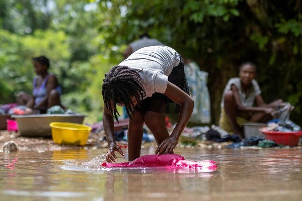 Bé gái giặt quần áo ở một con sông trong khu Camp Perrin ở Les Cayes ngày 22/8.