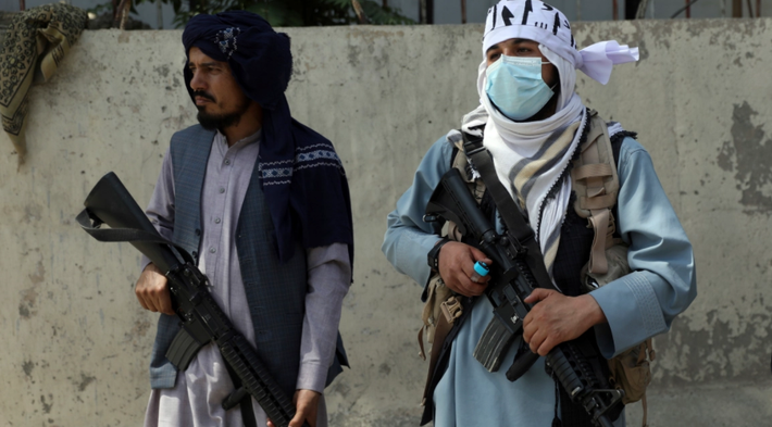 Chiến binh Taliban đứng gác ở cổng chính dẫn vào Dinh Tổng thống Afghanistan tại Kabul.