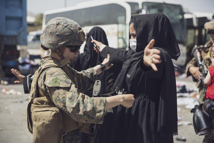 Lính thủy quân lục chiến Mỹ kiểm tra một phụ nữ tại sân bay quốc tế Hamid Karzai ở Kabul ngày 28/8.