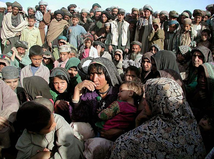 Các gia đình Afghanistan sơ tán chờ đợi tại một địa điểm ở Herat, Afghanistan, để được chuyển đến các trung tâm do Liên Hợp Quốc bảo trợ, vào tháng 5/2001.
