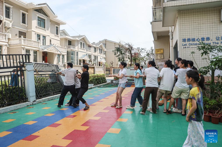 Các giáo viên kéo hàng rào bị nghiêng tại một trường mẫu giáo ở Hải Khẩu, tỉnh Hải Nam, ngày 8/9.