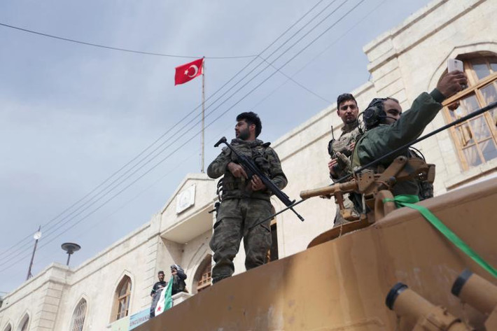 Binh sĩ Thổ Nhĩ Kỳ và lực lượng FSA tuần tra trên đường phố Afrin ngày 18/3. Ảnh: Reuters.