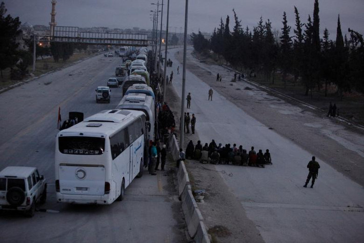Các tay súng phiến quân Syria cầu nguyện trước khi lên xe buýt rời khỏi "tử địa" Đông Ghouta.