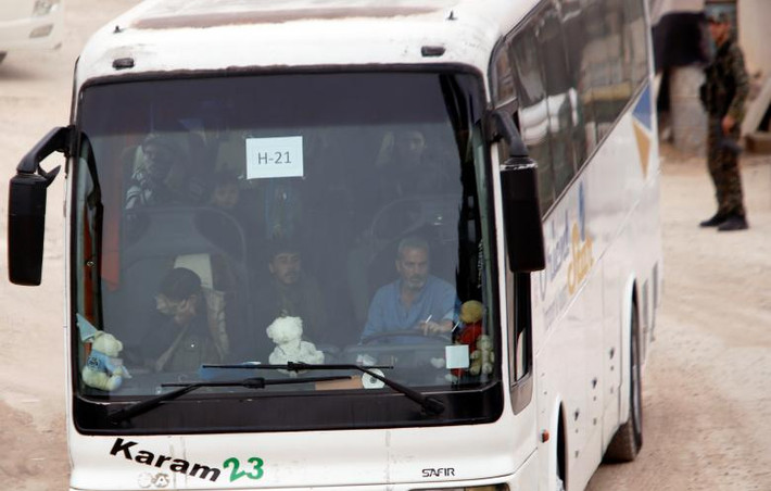 Một chiếc xe buýt chở phiến quân Syria cùng người thân của họ rời khỏi Harasta.