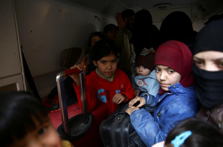 Các em nhỏ tập trung tại một địa điểm khi chuẩn bị sơ tán khỏi thị trấn Douma, Syria. Ảnh: Reuters.