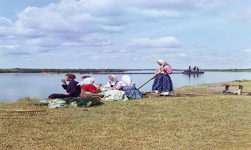 Những người phụ nữ ngồi ăn và trò chuyện với nhau cạnh bờ sông năm 1909.