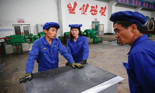Những người công nhân trao đổi với nhau tại nhà máy sản xuất cáp điện 326 ở thủ đô Bình Nhưỡng tháng 5/2016.