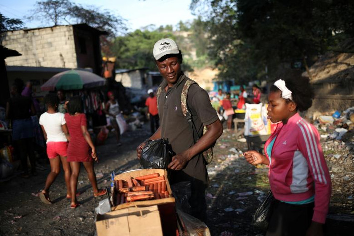 Người đàn ông bán xúc xích trong một khu chợ ở Port-au-Prince ngày 15/3.