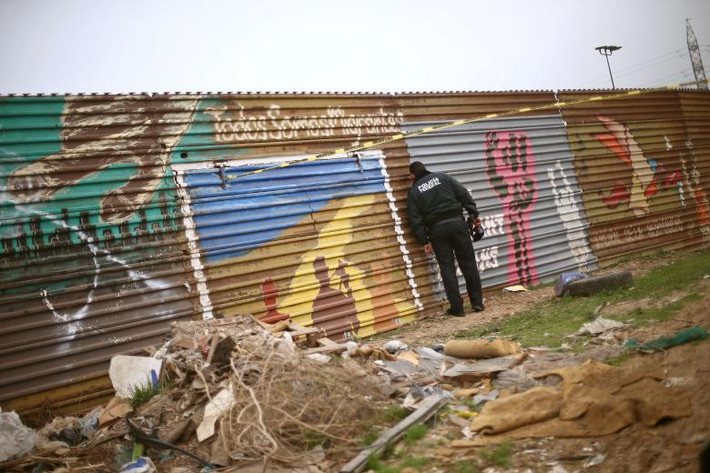 Cảnh sát Mexico ngó sang phía bên kia hàng rào biên giới ở Tijuana, Mexico.