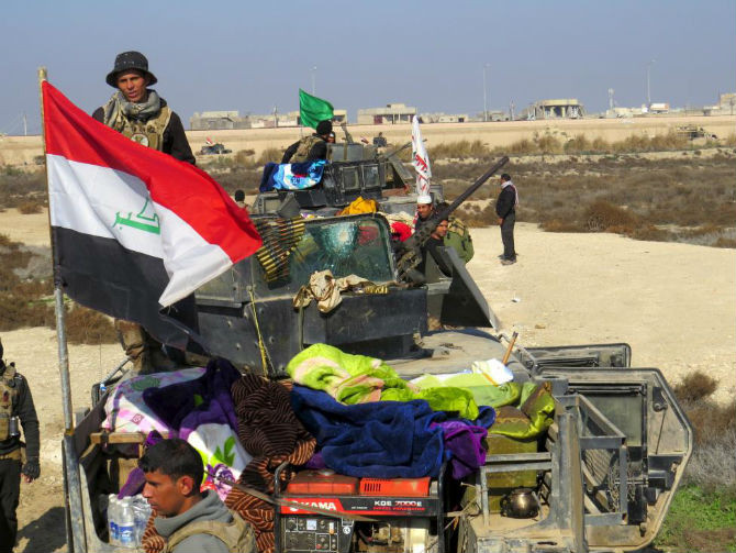 Ngày 22/12, quân đội Iraq mở cuộc tấn công nhằm vào tổ chức khủng bố IS tại tỉnh Anbar. Mục đích chính của chiến dịch quân sự này là nhằm giải phóng Ramadi – thành phố lớn nhất của tỉnh Anbar – khỏi tay phiến quân IS. Ảnh: Lực lượng an ninh Iraq tập trung để tiến vào trung tâm thành phố Ramadi ngày 22/12.