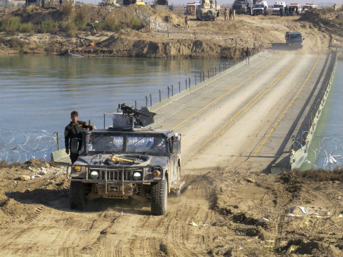 Binh sĩ Iraq đi qua một cây cầu bắc qua sông Euphrates ở Ramadi ngày 22/12.