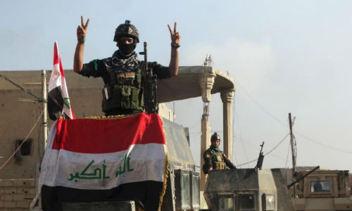 Binh sĩ Iraq giơ biểu tượng chiến thắng tại tòa thị chính ở thành phố Ramadi ngày 28/12.