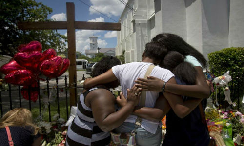 Vụ xả súng nhằm vào nhà thờ Emanuel African Methodist Episcopal ở Charleston, Nam Carolina ngày 20/6/2015 đã khiến ít nhất 9 người thiệt mạng. Ảnh: Người dân tưởng niệm các nạn nhân xấu số.