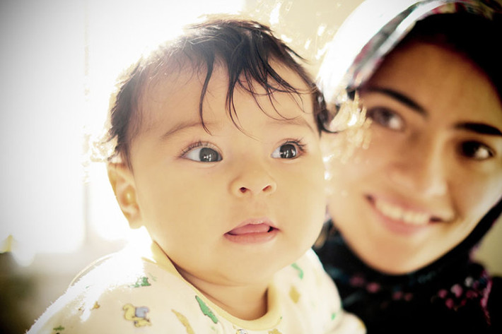Gương mặt hồn nhiên của bé Zaineb Husseini, 6 tháng tuổi, khi bên cạnh mẹ Zahra Husseini, 18 tuổi, đến từ Ghazni, Afghanistan trong một căn phòng tại trung tâm tị nạn ở Viên, Áo.