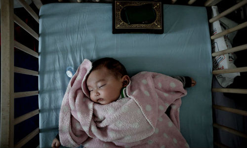 Bé sơ sinh 4 tháng tuổi đến từ Parwan, Pakistan, Yasmin Sultani, đang nằm ngủ tại một khu trại tị nạn ở Viên, Áo.