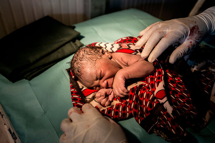 Theo giám đốc UNICEF, Anthony Lake, cứ hai giây lại một đứa trẻ sinh ra trong chiến tranh, thường trong tình cảnh lo sợ và không được tiếp cận với chăm sóc y tế. Rất nhiều đứa trẻ mới ra đời phải sống trong cảnh nghèo đói, bệnh dịch và thiếu dinh dưỡng. Ảnh: Julie Akol bế cậu con trai mới chào đời của cô.