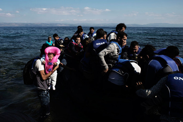 Một em nhỏ Syria được bế lên bờ sau khi tới đảo Lesbos, Hy Lạp.