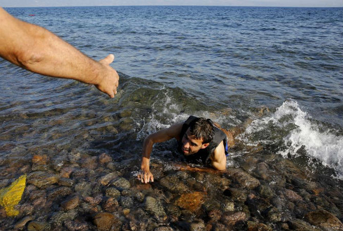 Một người tị nạn Syria nhảy khỏi một con thuyền đang chìm giữa biển và cố hết sức bơi vào bờ ở đảo Lesbos, Hy Lạp ngày 17/9/2015.