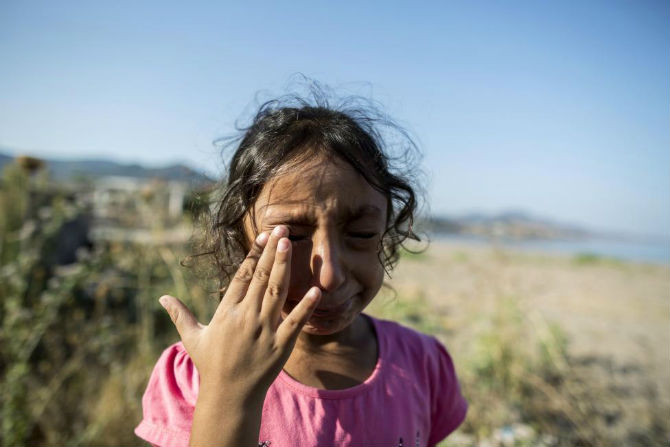 Cô bé Yasmine, 6 tuổi, đến từ vùng Deir al-Zour, Syria, bật khóc sau khi đặt chân lên đảo Lesbos, Hy Lạp, ngày 11/9/2015.