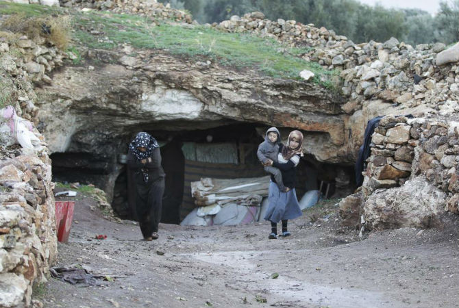 Người dân Syria bước ra khỏi một hang động ngầm ở Jabal al-Zawiya ở tỉnh Idlib ngày 26/11/2014.
